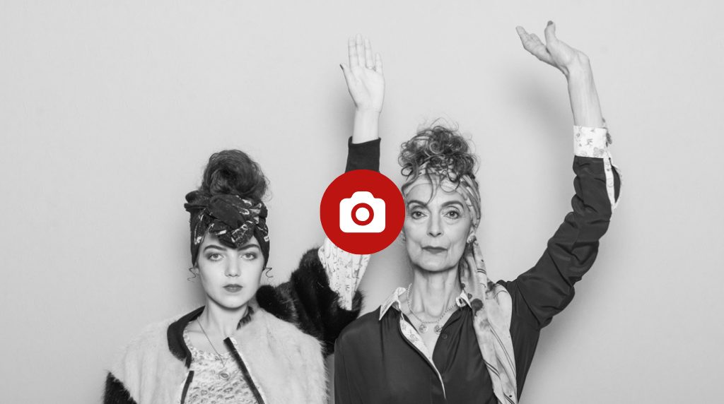 Models Pam Lucas and Eva Calcasola raise their hands in a fashion shoot